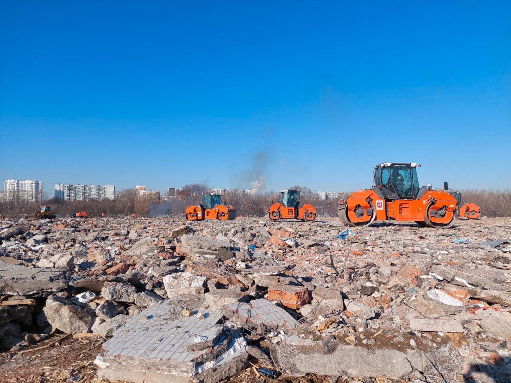 Техника выравнивает рельеф, засыпая слой строительного мусора, в том числе крупные обломки снесенных по реновации домов