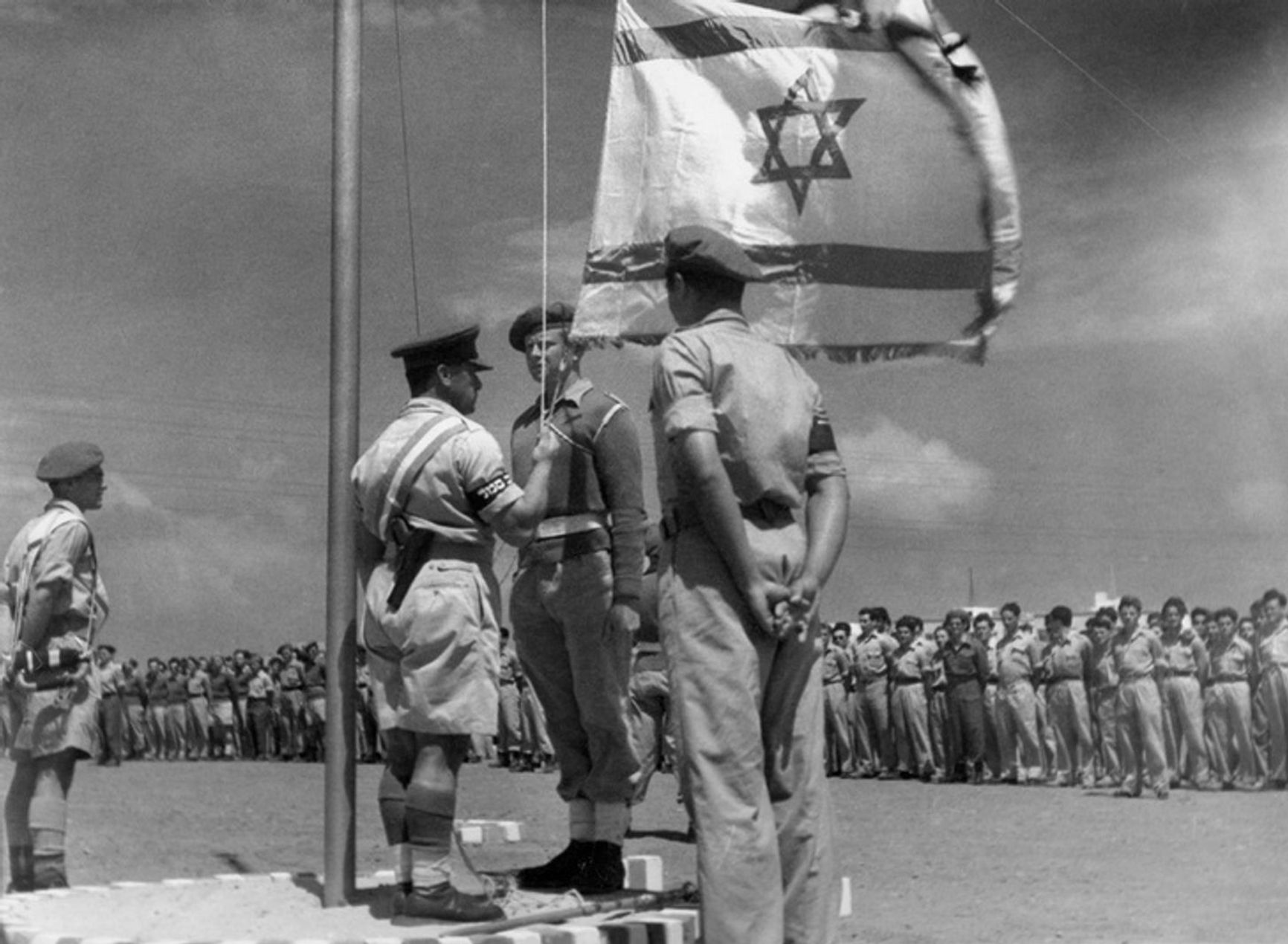 An Israeli officer raises the national flag for the first time on June 8, 1948