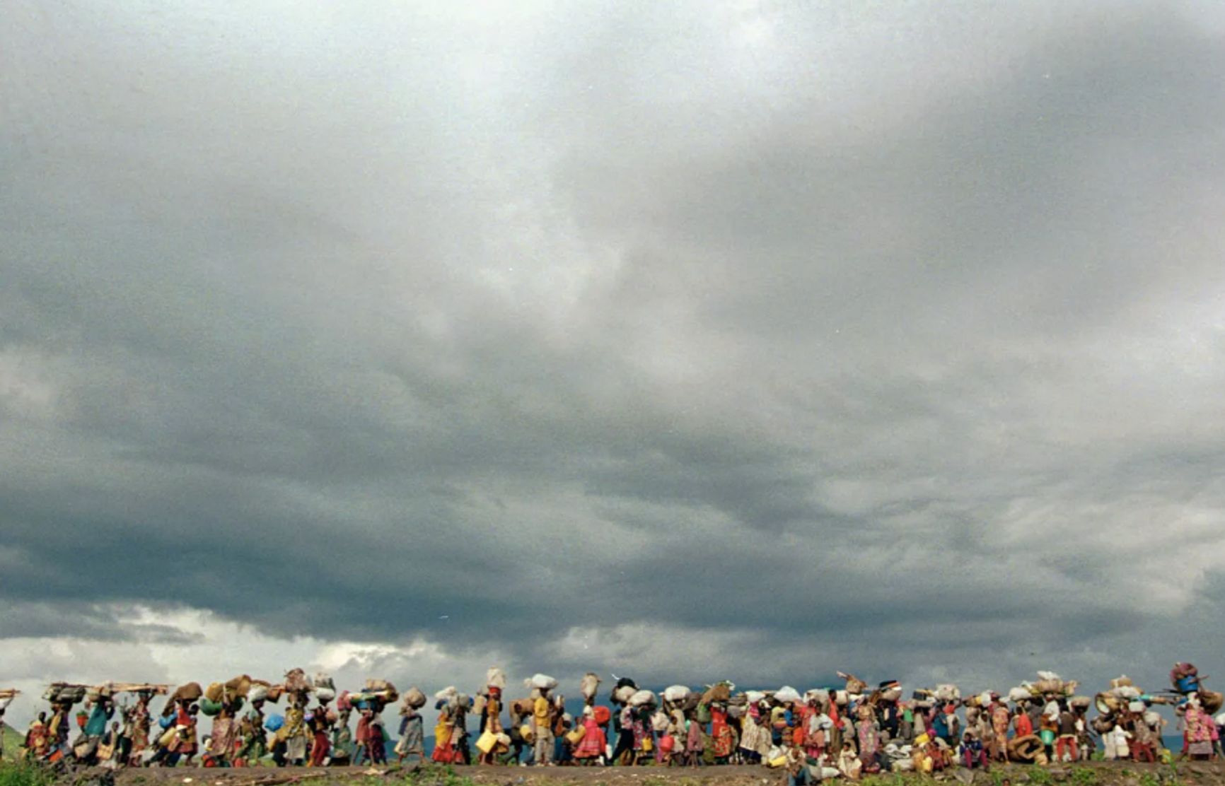 Беженцы выходят из лагеря беженцев Мугунга в восточной части Заира к границе с Руандой 15 ноября 1996 года