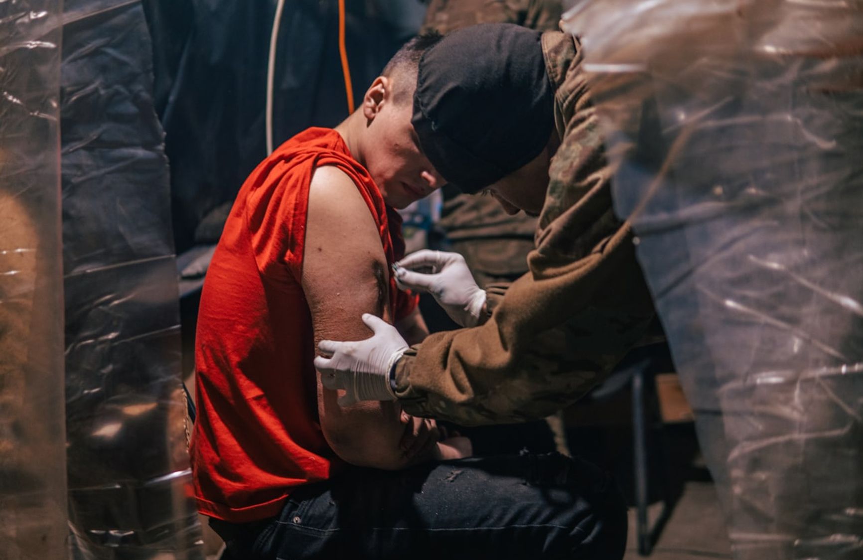 Медик оказывает помощь одному из бойцов, защищающих завод «Азовсталь»