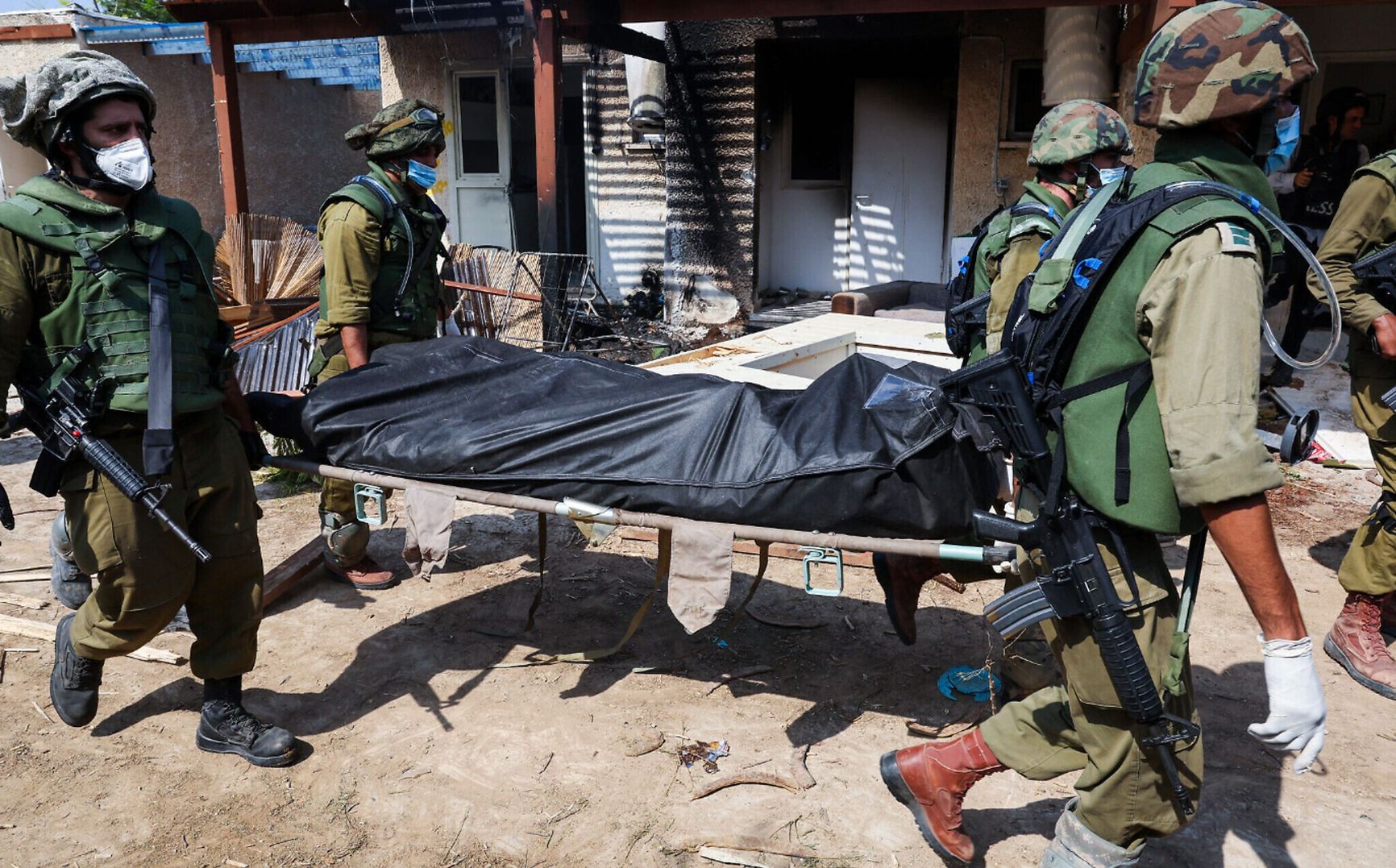 Israeli soldiers carrying a body in the Kfar Aza Kibbutz