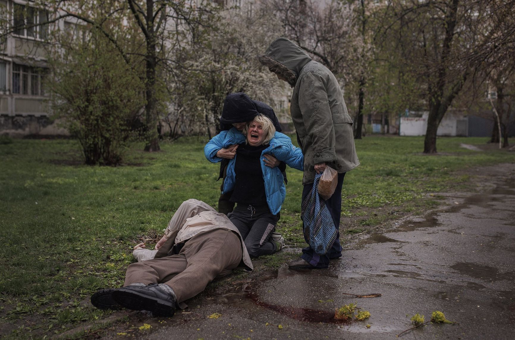 Consoled by her partner Yevgeniy Vlasenko and her mother Lyubov, Yana Bachek cries over the body of her father Victor Gubarev (79), killed while buying bread during the shelling of Kharkiv, Ukraine.