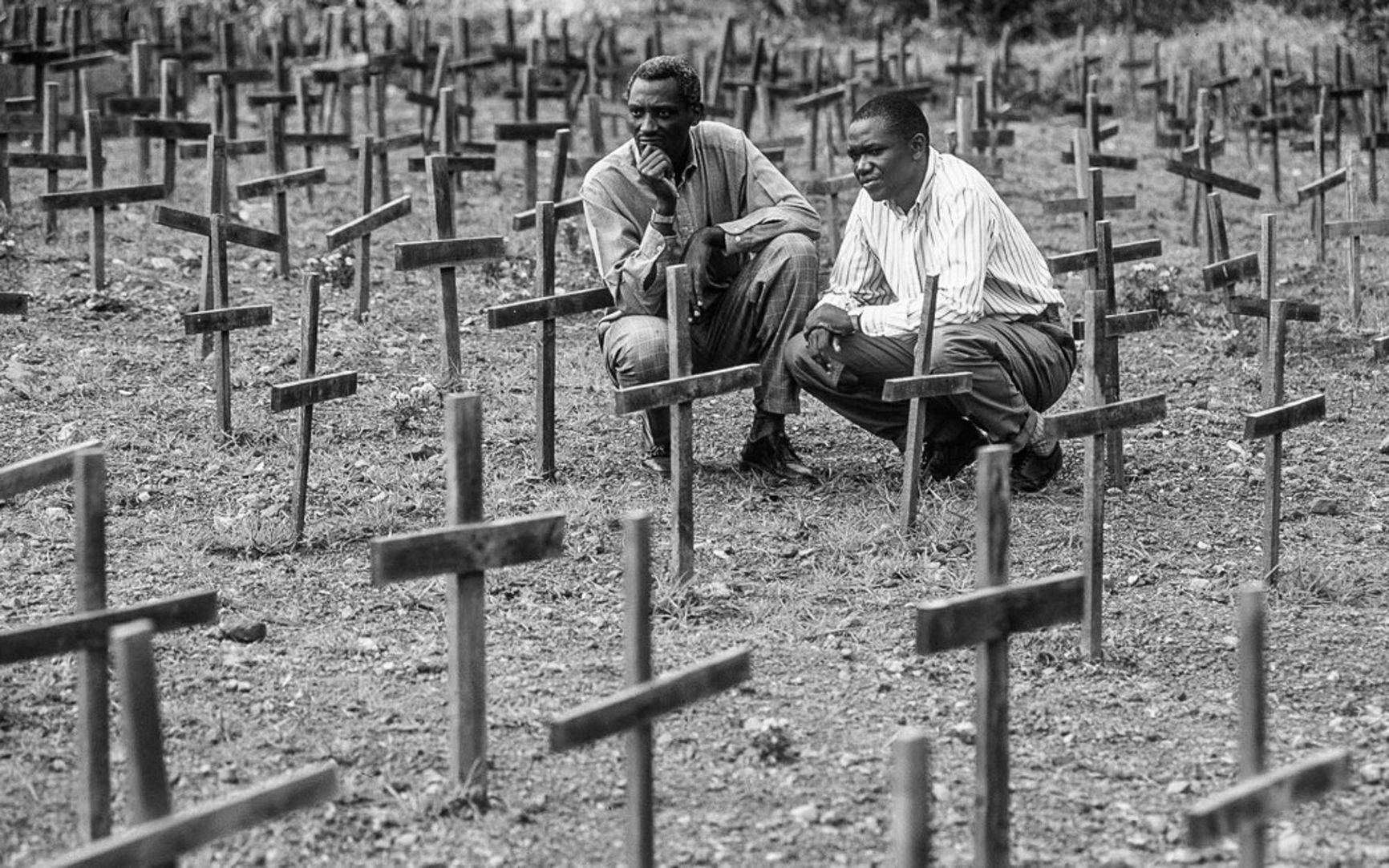 Two Tutsis at the site of a village where all the inhabitants were killed