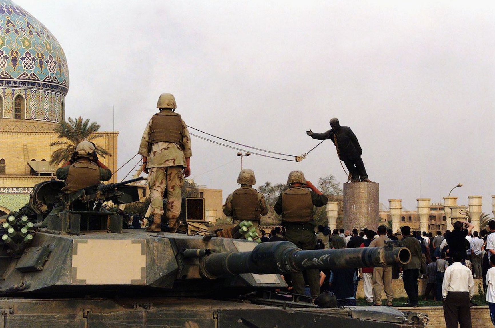 Американские солдаты наблюдают за сносом памятника Саддаму Хусейну в Багдаде, 9 апреля 2003 года