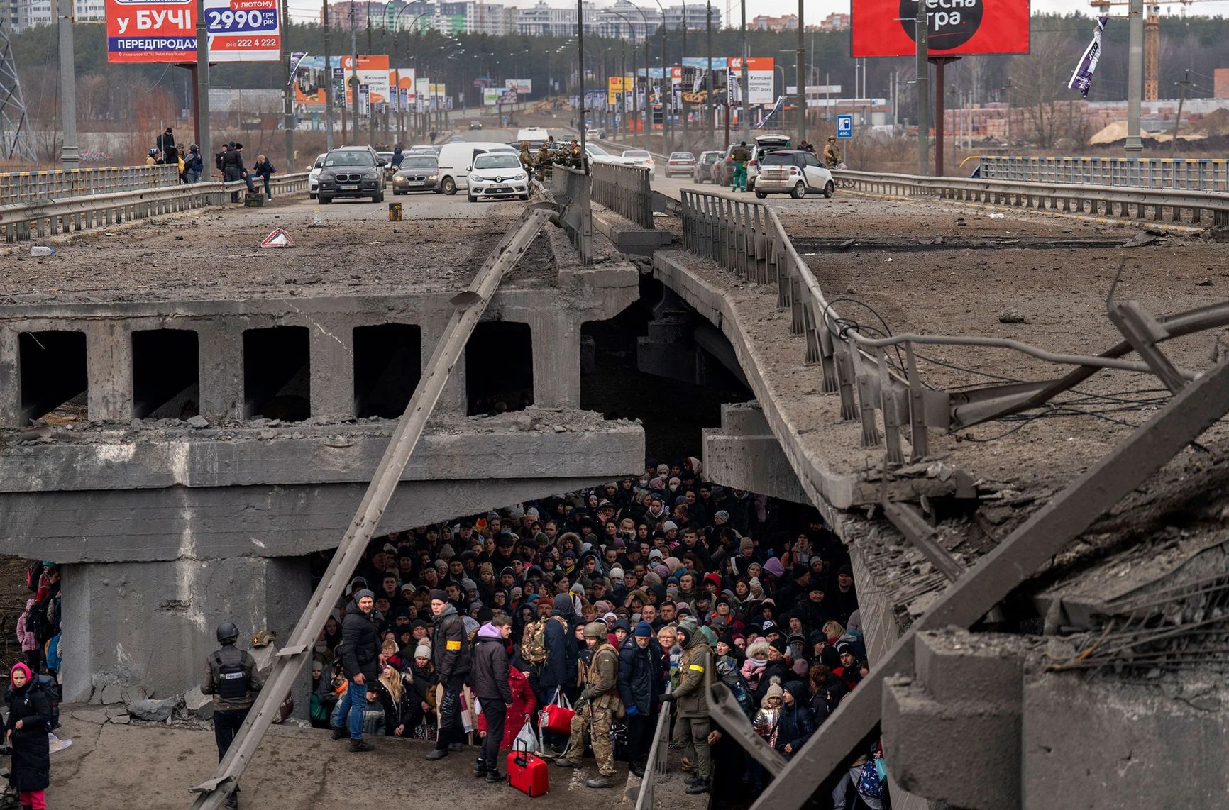 Украинцы под разрушенным мостом пытаются эвакуироваться через реку из Ирпеня на окраине Киева, Украина, 5 марта