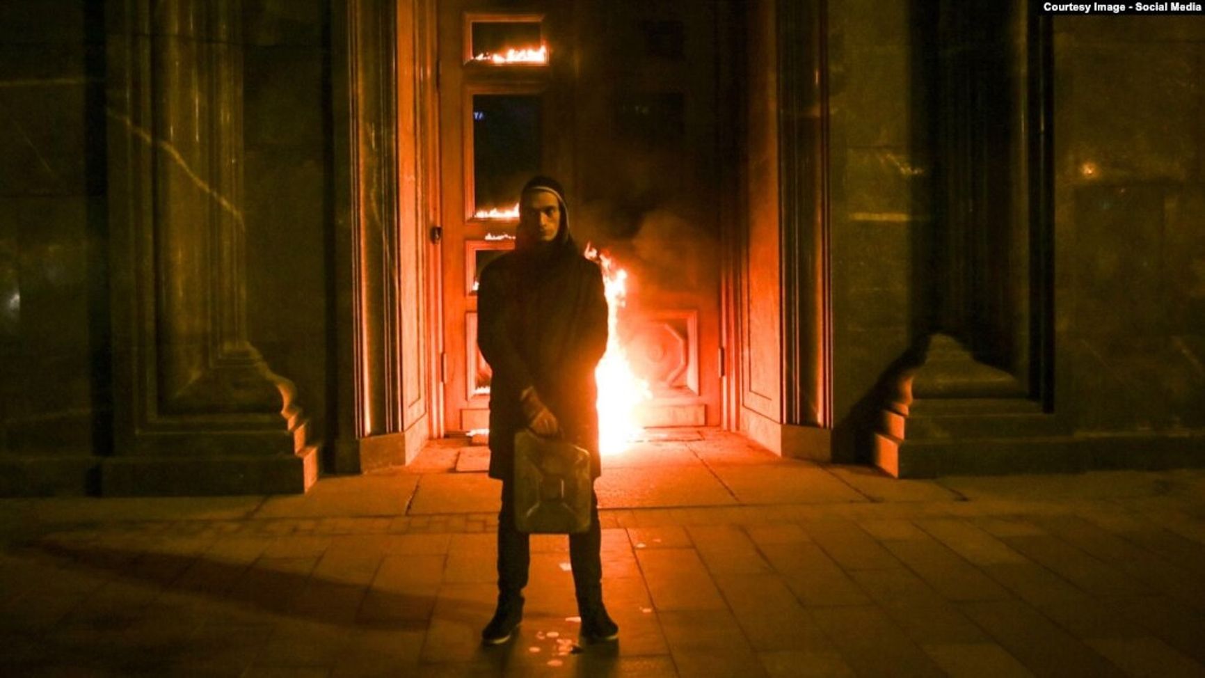 Artist Pyotr Pavlensky in front of the burning entrance to the main building of the Russian Federal Security Service. “The Threat” performance