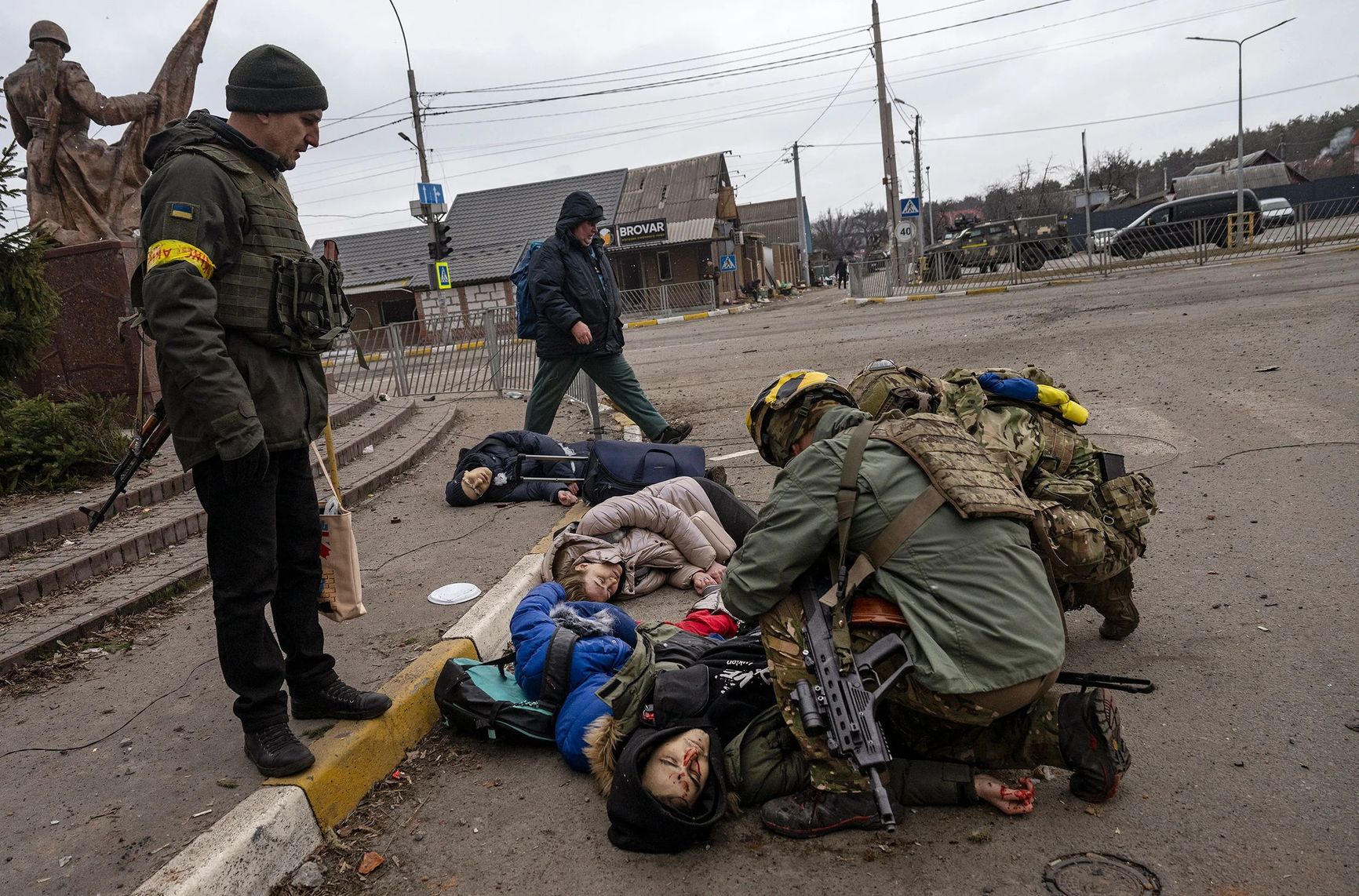 Ukrainian soldiers attend to a group of civilians, including Tetiana Perebyinis and her two children, who were mortally wounded by a Russian mortar round while they evacuated from Irpin, Ukraine, on March 6. A volunteer assisting the family was also killed.