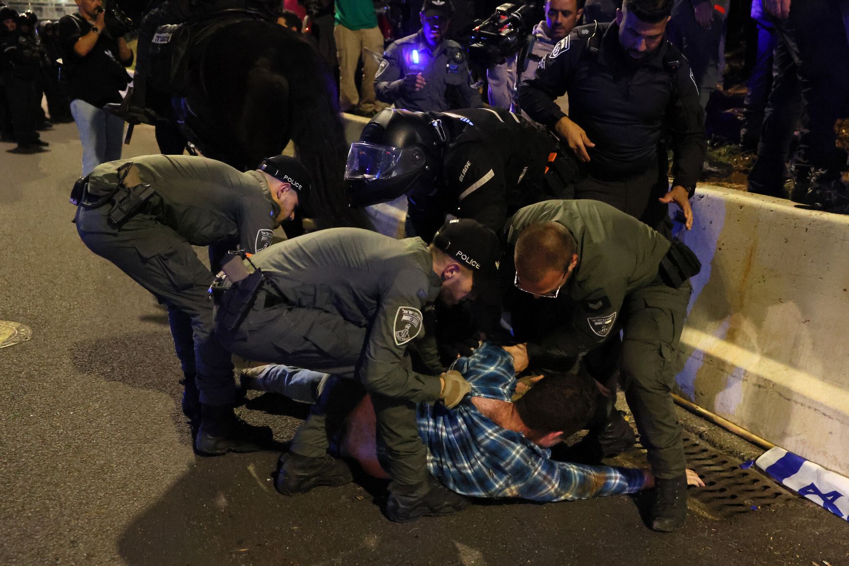 Израильская полиция задерживает протестующего во время демонстрации против планов правительства по пересмотру судебной системы в Тель-Авиве 15 апреля 2023 года