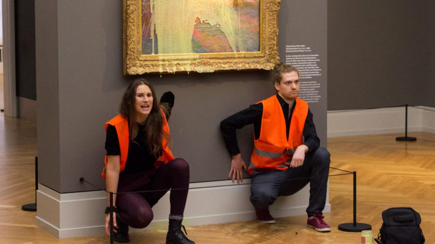 Активисты приклеили себя к стенду, на котором висит картина Моне, в музее Барберини в Потсдаме. Октябрь 2022 года