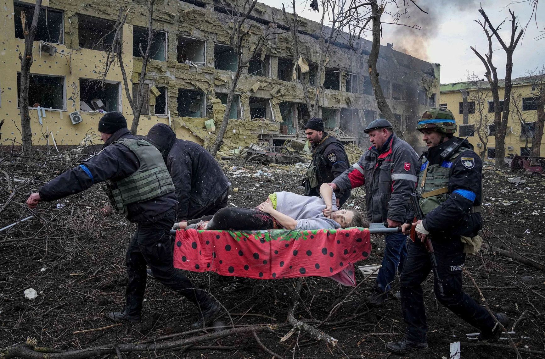 Украинские сотрудники МЧС и волонтеры выносят раненую беременную женщину из пострадавшего от обстрела родильного дома в Мариуполе, Украина, 9 марта. Ребенок родился мертвым. Через полчаса умерла и мать